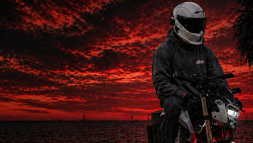 CBXX high-performance motorcycle streetwear header featuring a rider at sunset, cinematic red sky aesthetic.